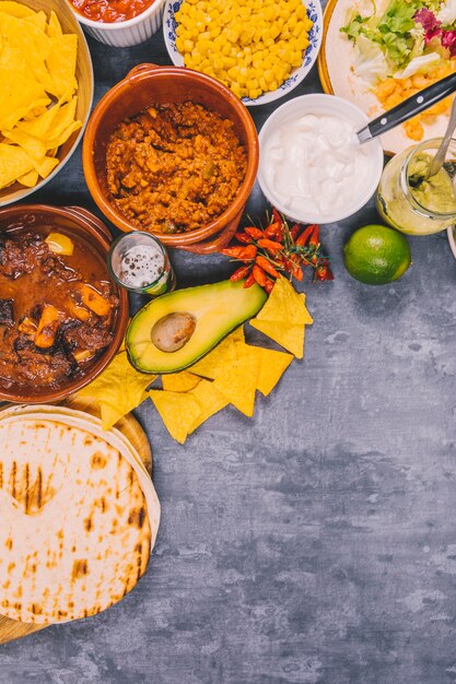 Variety of yummy mexican dishes over concrete background