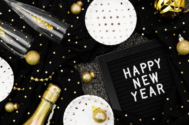 Free photo various accessories and glasses on black background and happy new year card