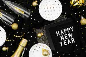 Free photo various accessories and glasses on black background and happy new year card