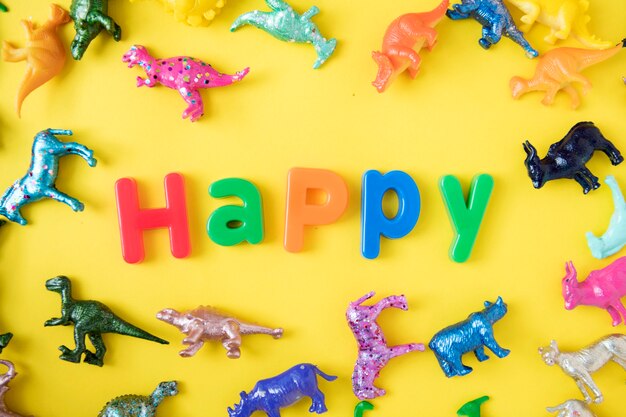 Various animal toy figures background with the word happy