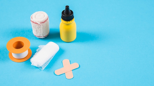 Free Photo various bandages with yellow bottle on blue background