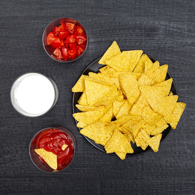 Free photo various bowls with nachos tomatoes red and white sauces