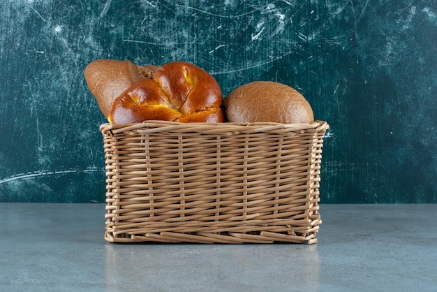 Free photo various bread and pastry in wooden basket.