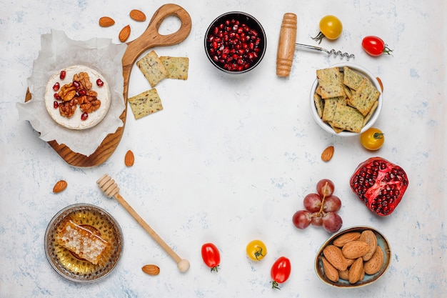 Various cheese and cheese plate on light table with different nuts and fruits