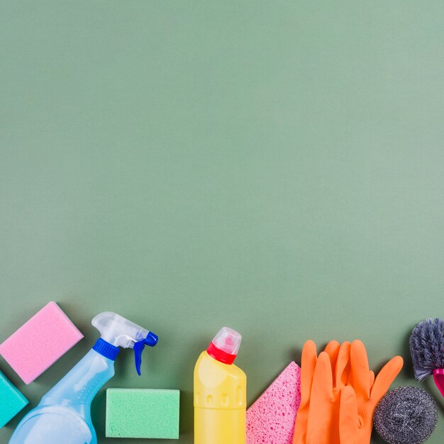 Various cleaning products at the bottom of green surface