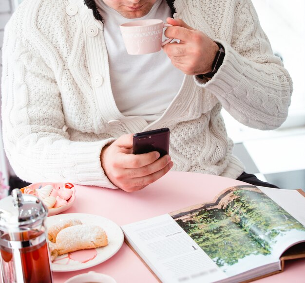 Various cookies with tea and magazine on the table