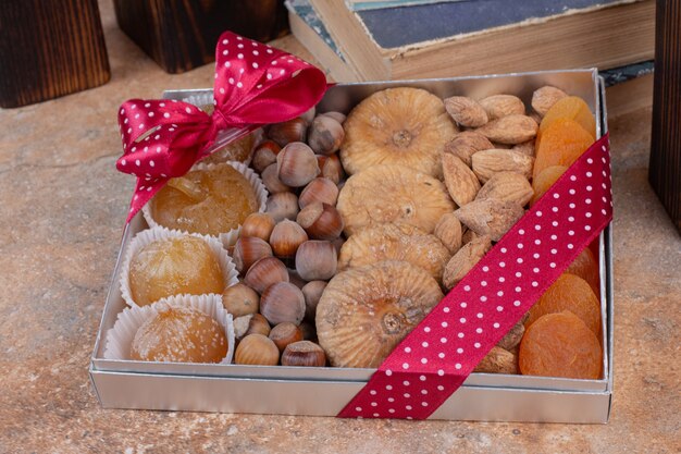 Various dried fruits and nuts on gift box.