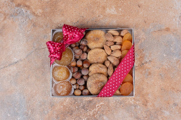 Various dried fruits and nuts on gift box.