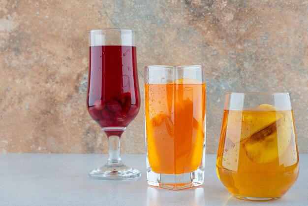 Various fruit lemonades on blue table.