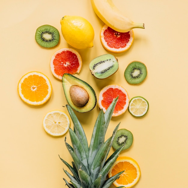 Various fruits near pineapple leaves