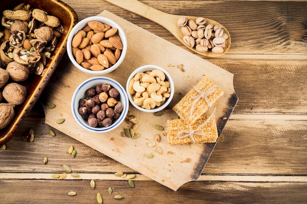 Various healthy ingredients and protein bar on chopping board