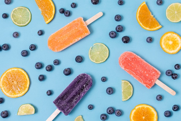 Free photo various of ice cream flavours on sticks with berries and citrus