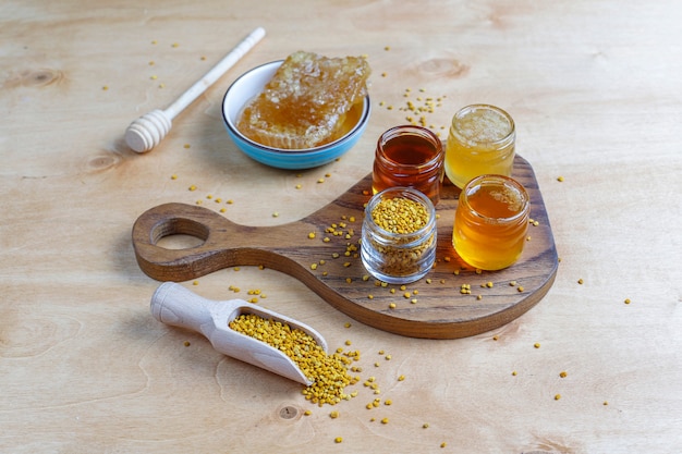 Free photo various kinds of honey in glass jars,honeycomb and pollen.