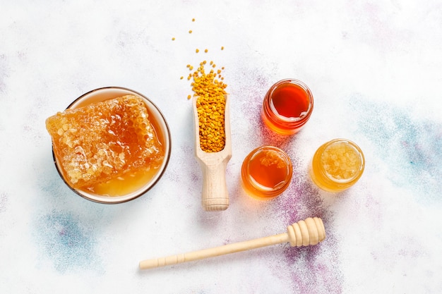 Free photo various kinds of honey in glass jars,honeycomb and pollen.