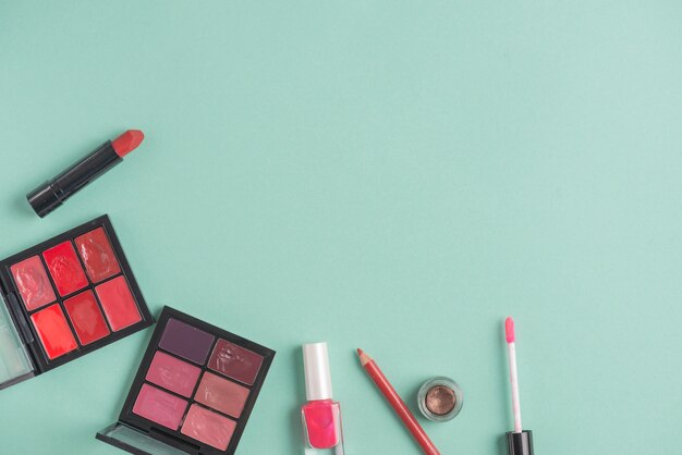 Various makeup products on green background