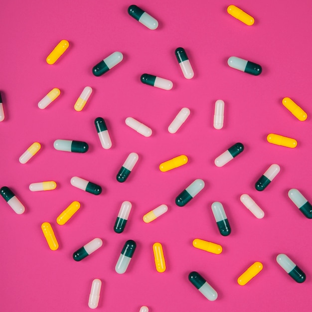 Free photo various pills on pink background