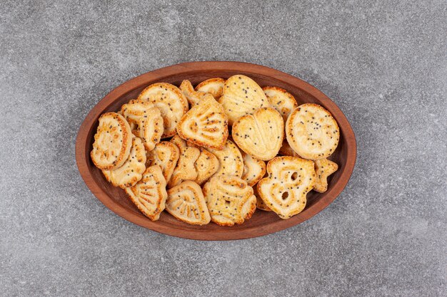 Various shaped biscuits on wooden plate