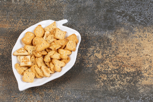 Various shaped salted crackers on leaf shaped plate. 