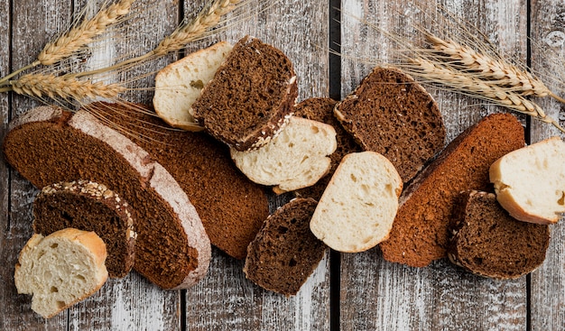 Free photo various slices of loaf on wooden plank background flat lay