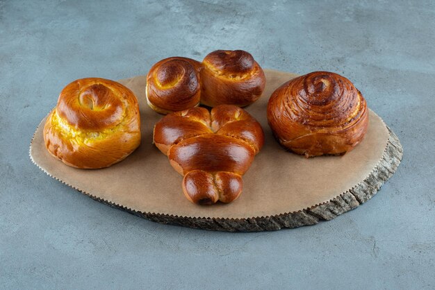 Various sweet pastries on wooden piece.