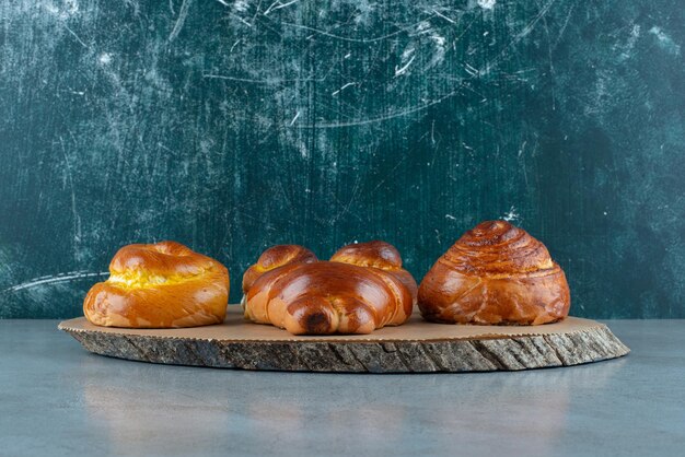 Various sweet pastries on wooden piece.