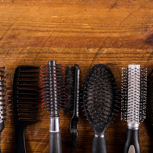 Various type of hair combs on wooden background