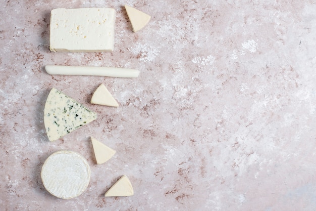 Various types of cheese on light  brown surface