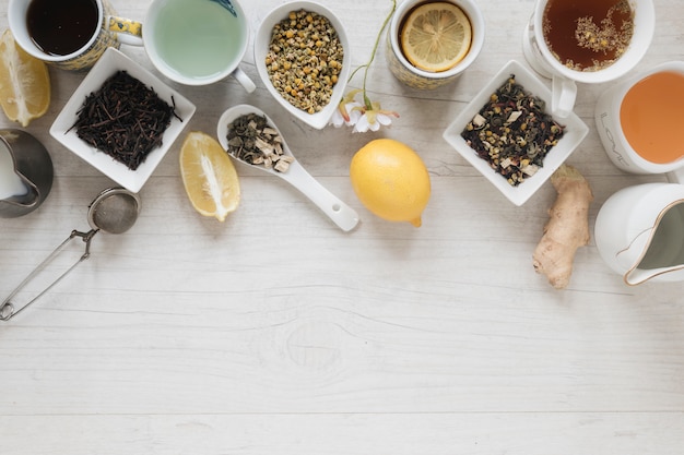 Various types of tea with herbs and dry leaves on wooden table