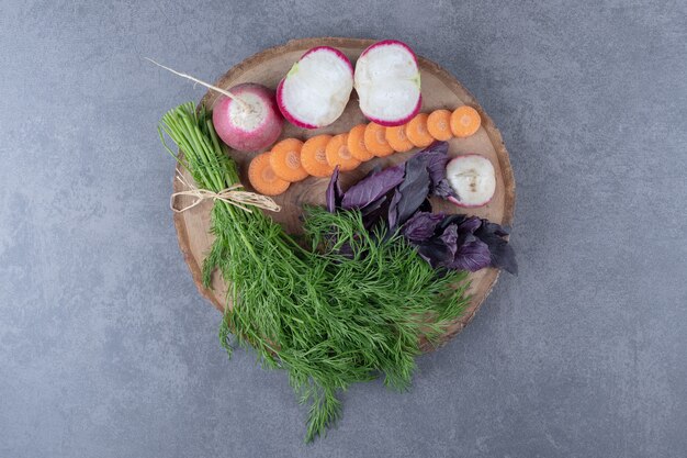 Various vegetables in a board, on the marble surface.