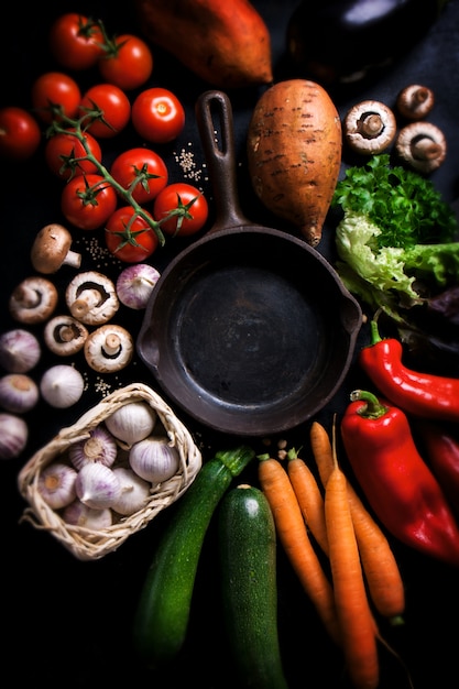 Free photo various vegetables surrounding an empty black pan