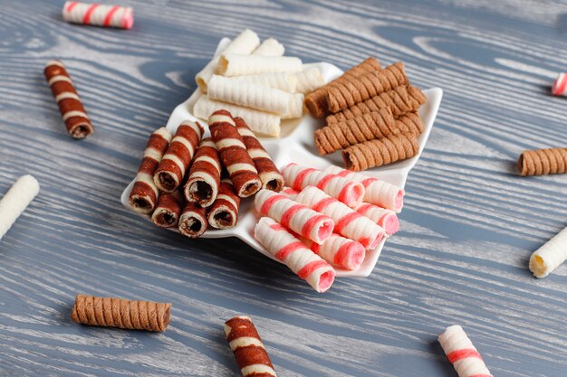 Various waffle rolls in ceramic plates,top view.