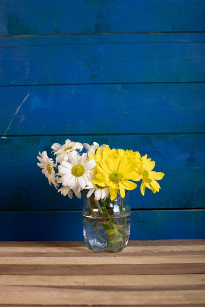 A vase of white and yellow flowers