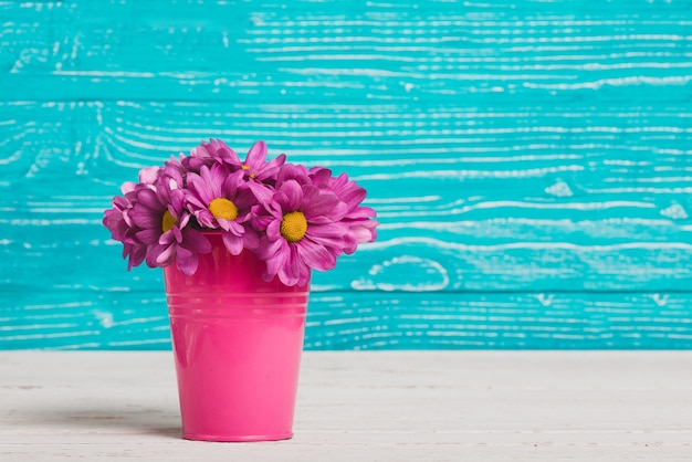 Free Photo vase with purple flowers and wooden background