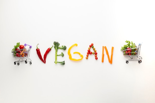 Free Photo vegan lettering made out of vegetables with tiny shopping carts