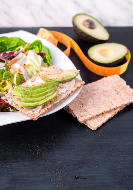 Free Photo vegetable salad with avocado on crisp bread on table 