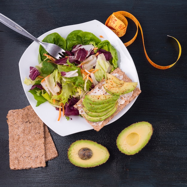 Free Photo vegetable salad with avocado on crisp bread 