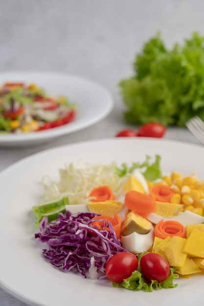 Vegetable salad with boiled eggs in a white dish.