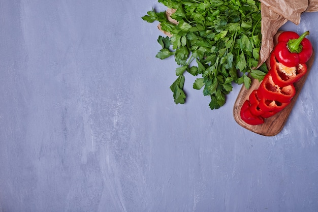 Vegetable salad with herbs and pepper on blue