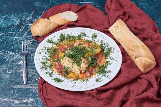 Free photo vegetable salad with herbs and spices served with baguette.