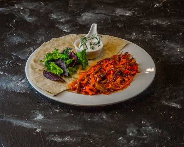 Vegetable stew in tomato sauce with herbs, lavash and white sauce.