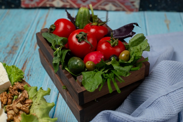 Free photo vegetable tray with tomatoes, herbs and cucumber.