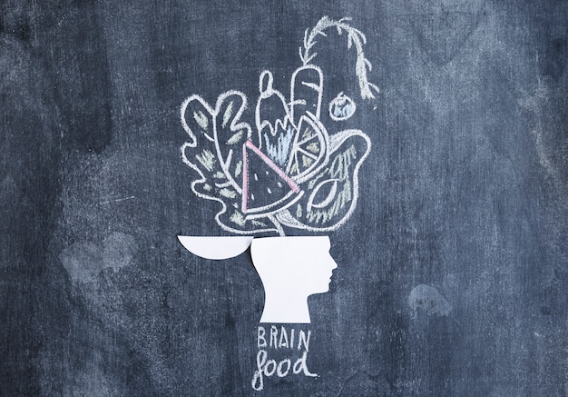 Free photo vegetables drawn over the open head on chalkboard