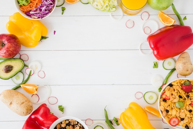 Vegetables; salad; fruits and cornflakes bowl on white wooden desk with space for writing the text