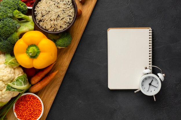 Vegetables with notebook and bell top view