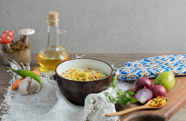 Free Photo vegetables on wooden board with bowl of noodles and oil bottle