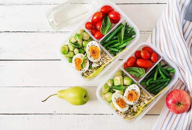 Free photo vegetarian meal prep containers with eggs, brussel sprouts, green beans and tomato. dinner in lunch box. top view. flat lay