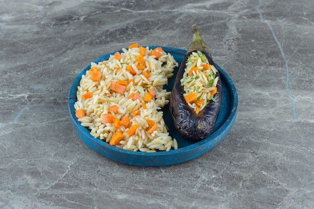 Free photo vegetarian rice in eggplant, on the plate , on the marble table.