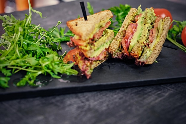 Free Photo vegetarian sandwich with salad and tomatoes on a wooden table surface.