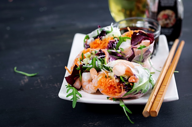 Vegetarian vietnamese spring rolls with spicy shrimps, prawns, carrot, cucumber, red cabbage and rice noodle.