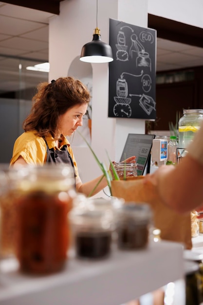 Free photo vendor scans food items in bio shop